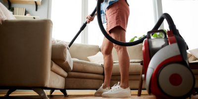 Cleaning sofa with vacuum cleaner